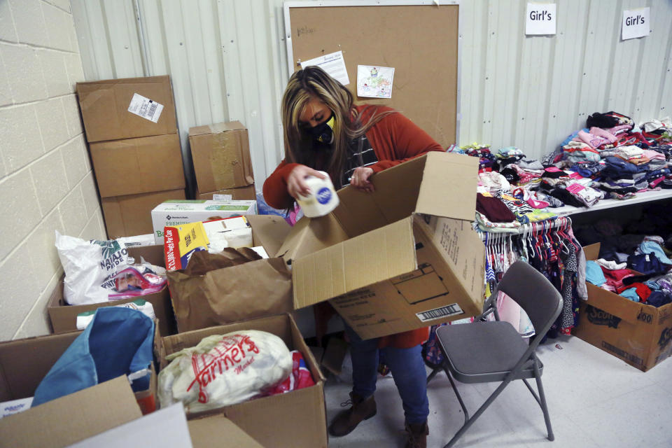 Social worker Victoria Dominguez collects supplies at Cuba High School to deliver along a rural school bus route outside Cuba, N.M., Oct. 19, 2020. The switch to remote learning in rural New Mexico has left some students profoundly isolated — cut off from others and the grid by sheer distance. The school system is sending school buses to students’ far-flung homes to bring them assignments, meals and a little human contact. (AP Photo/Cedar Attanasio)