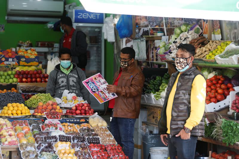 Foto del jueves de vendedores con máscaras en una verdulería en Manamá, Bahréin