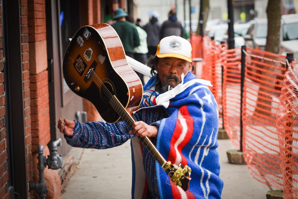 Rainbow shows off his guitar while roaming around along Varick Street during Saint Patrick's Day festivities in 2020 in Utica.