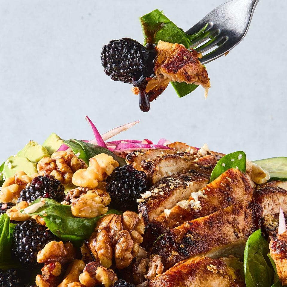 salad with sliced chicken, blackberries, sliced cucumber, red onion, and walnuts