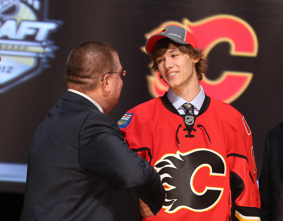 PITTSBURGH, PA - JUNE 22: Mark Jankowski (R), 21st overall pick by the Calgary Flames, shakes hands with a Flames representative on stage during Round One of the 2012 NHL Entry Draft at Consol Energy Center on June 22, 2012 in Pittsburgh, Pennsylvania. (Photo by Bruce Bennett/Getty Images)