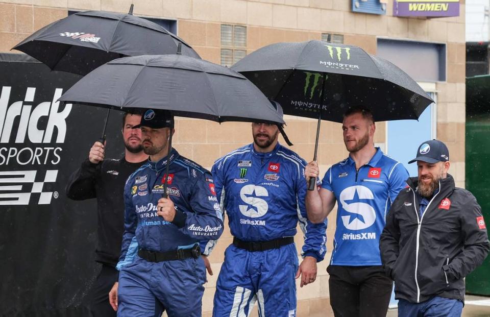 NASCAR Cup Series driver Martin Truex Jr. walks to his trailer with some team members during a pre-race rain delay at Kansas Speedway on Sunday.