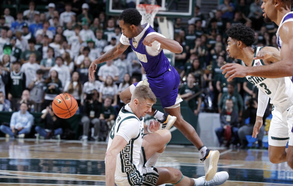 Alcorn State's Byron Joshua, top center, leaps over Michigan State's Carson Cooper, bottom center, during the first half of an NCAA college basketball game, Sunday, Nov. 19, 2023, in East Lansing, Mich. (AP Photo/Al Goldis)