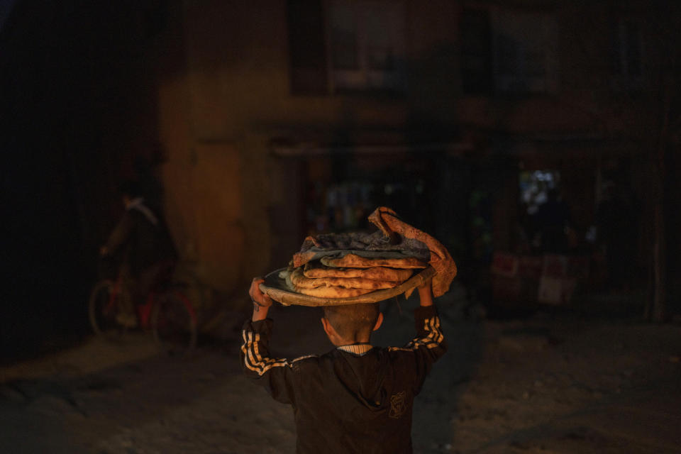 A Afghan boy carries bread to his home in Kabul, Afghanistan, Tuesday, Nov. 16, 2021. (AP Photo/Petros Giannakouris)