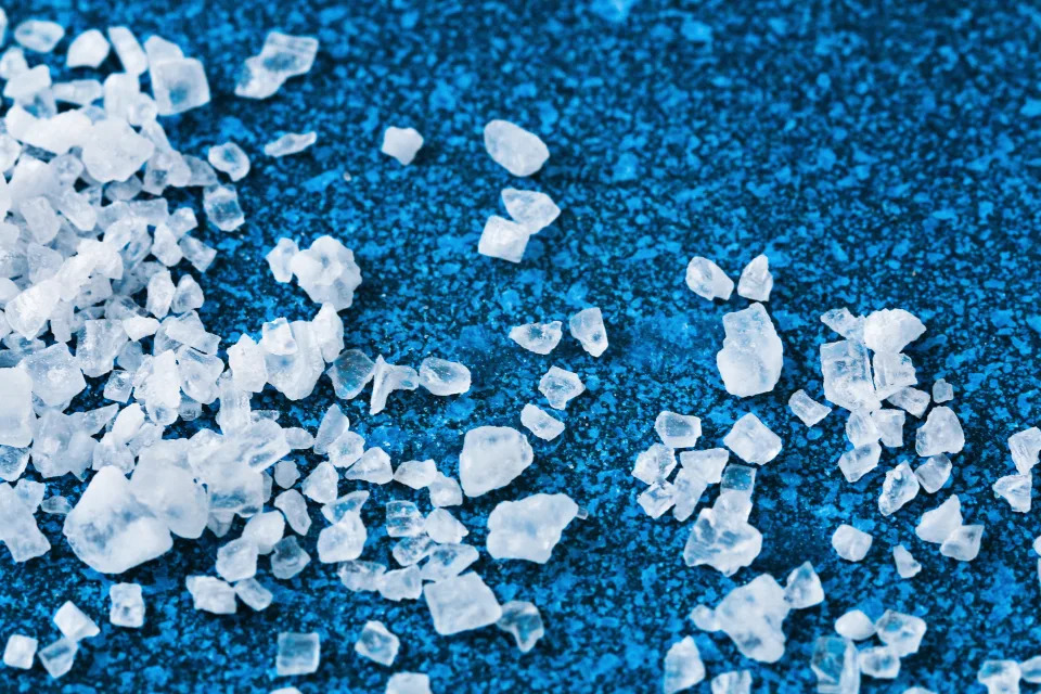 Salt used to remove snow and ice on a blue background