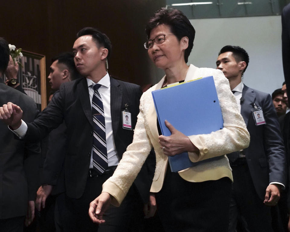 FILE - In this Oct. 17, 2019, file photo, Hong Kong Chief Executive Carrie Lam, center, arrives at chamber of the Legislative Council in Hong Kong. Hong Kong is feuding with Taiwan over a fugitive murder suspect whose case indirectly sparked the protests in Hong Kong over an extradition bill. Hong Kong officials pleaded on Tuesday, Oct. 22, for authorities in Taiwan to let the man surrender himself for killing his girlfriend while visiting the self-ruled island last year.(AP Photo/Vincent Yu, File)