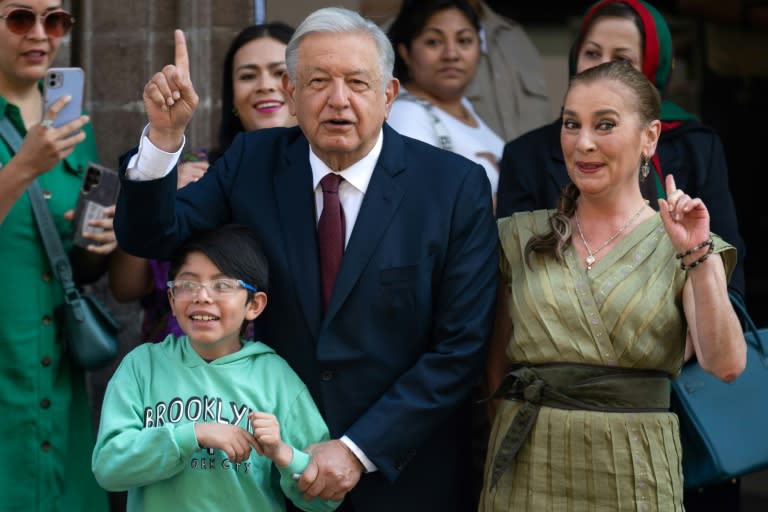El presidente meexicanode México, Andrés Manuel López Obrador (C), y su esposa, Beatriz Gutiérrez Muller, geticulan en un centro de votación en Ciudad de México, el 2 de junio de 2024 (Gerardo Luna)