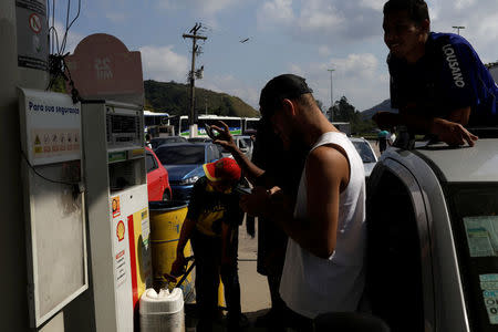 A man fills a canister with fuel at a gas station in Mage near Rio de Janeiro, Brazil May 25, 2018. REUTERS/Ricardo Moraes