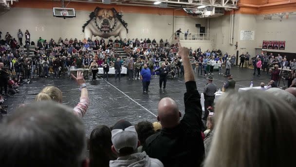 PHOTO: A man raises his hand with a question for East Palestine Mayor Trent Conaway, center, during a town hall meeting at East Palestine High School in East Palestine, Ohio, on Feb. 15, 2023, following the derailment of a train carrying toxic chemicals. (Gene J. Puskar/AP)