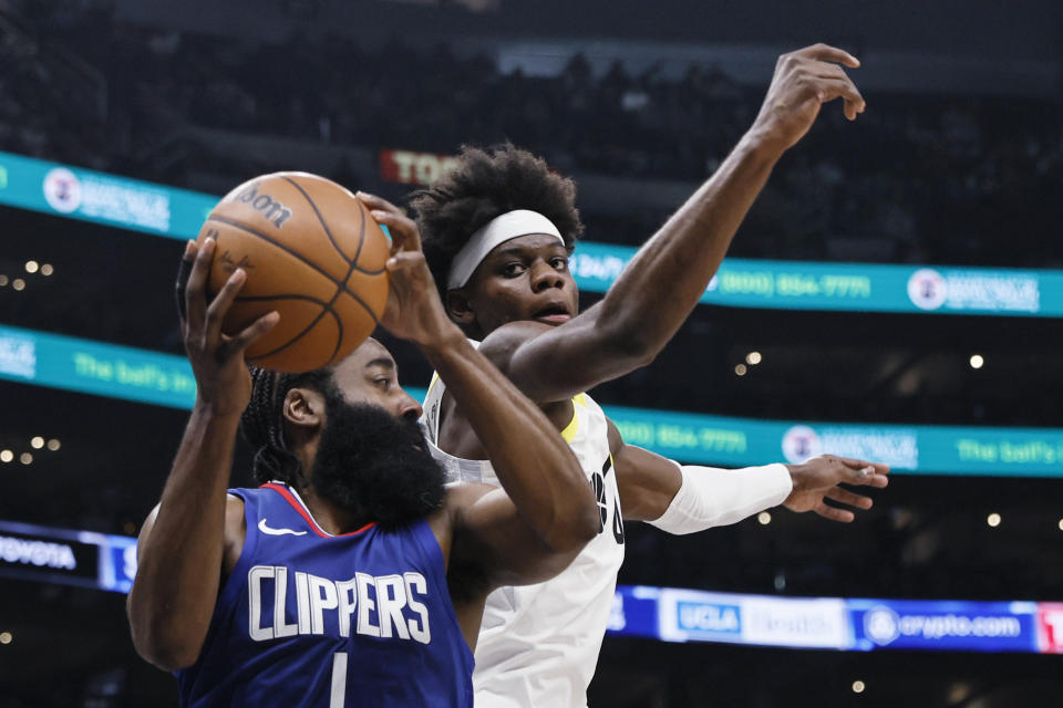 Los Angeles Clippers guard James Harden, left, grabs a rebound next to Utah Jazz forward Taylor Hendricks during the second half of an NBA basketball game Friday, April 5, 2024, in Los Angeles. (AP Photo/Etienne Laurent)