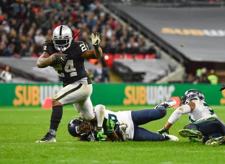 Oct 14, 2018; London, United Kingdom; Oakland Raiders running back Marshawn Lynch (24) is tackled during the third quarter of the game against the Seattle Seahawks during an International Series game at Wembley Stadium. Mandatory Credit: Steve Flynn-USA TODAY Sports