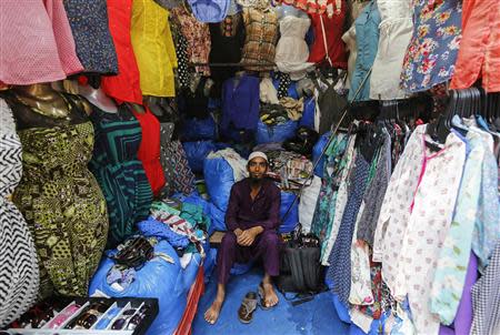 Mohammad Sabir, a 20-year-old salesman, poses inside his roadside shop at a market in Mumbai March 24, 2014. REUTERS/Danish Siddiqui