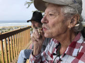 ADVANCE FOR PUBLICATION ON TUESDAY, JUNE 11, AND THEREAFTER - In this April 25, 2019, photo, two-time cancer survivor and medical marijuana cardholder Bill Blazina, 73, smokes a marijuana joint on the deck of his neighbor's home in Waldport, Ore. Blazina also uses a high-potency marijuana oil as a medical marijuana patient but he can't afford it at a recreational marijuana store. Blazina has learned how to make his own oil in a rice cooker after watching online videos. (AP Photo/Gillian Flaccus)