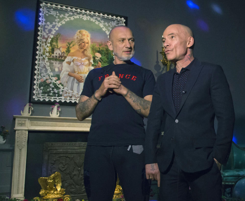French artists Pierre Commoy, left, and Gilles Blanchard, known as Pierre et Gilles, pose inside their installation at the Gobelins Gallery in Paris, Monday, April 7, 2014. Pierre Commoy and Gilles Blanchard, who have established a strong reputation in Europe and beyond for shock ever since their stylized, hand-painted homoerotic photos first appeared nearly 40 years ago. Today, their iconic images of stars such as Madonna, Kylie Minogue, Mick Jagger and Catherine Deneuve which appear alongside naked gay porn stars in glittering and fantastical scenes line coffee-tables the world over and have titillated millions. (AP Photo/Michel Euler)