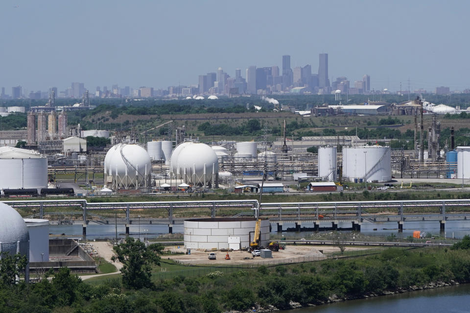 In this Thursday, April 30, 2020, photo storage tanks along the Houston Ship Channel are seen with downtown Houston in the background. Like in other cities, the coronavirus has shut down much of Houston's economic activity, slashing thousands of jobs, while at the same time, the price of oil plunged below zero recently as demand plummeted due to the worldwide lockdown to stop the spread of the virus. This one-two punch from COVID-19 and the collapse in oil prices will make it much harder for Houston to recover from a looming recession, according to economists. (AP Photo/David J. Phillip)