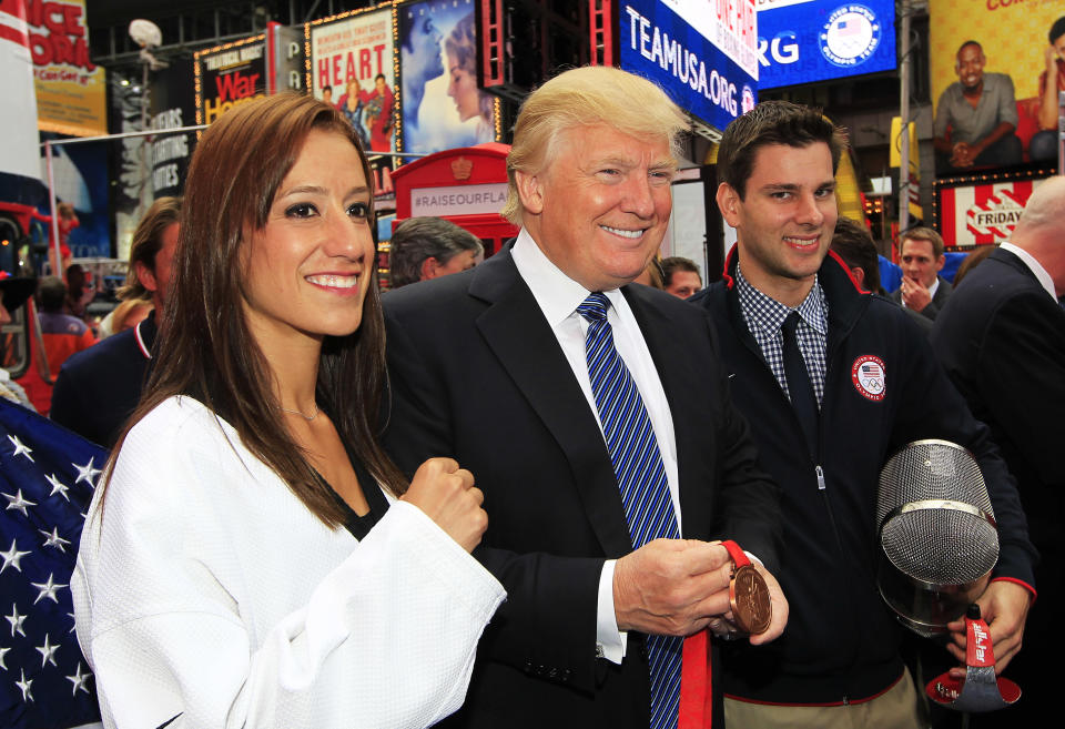 Donald Trump poses for a photo with Taekwando athlete Diana Lopez and fencer Tim Morehouse (R) during the Team USA Road to London 100 Days Out Celebration in Times Square on April 18, 2012 in New York City. (Photo by Chris Trotman/Getty Images for USOC)