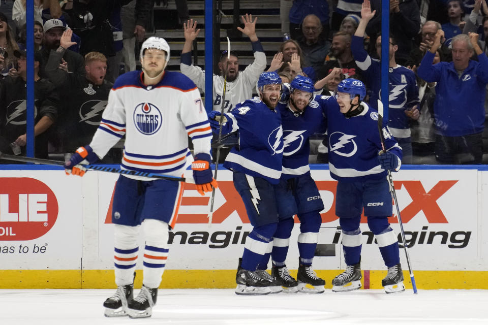 Tampa Bay Lightning center Luke Glendening (11) celebrates his goal against the Edmonton Oilers with defenseman Calvin de Haan (44) and left winger Cole Koepka (45) during the third period of an NHL hockey game Saturday, Nov. 18, 2023, in Tampa, Fla. (AP Photo/Chris O'Meara)