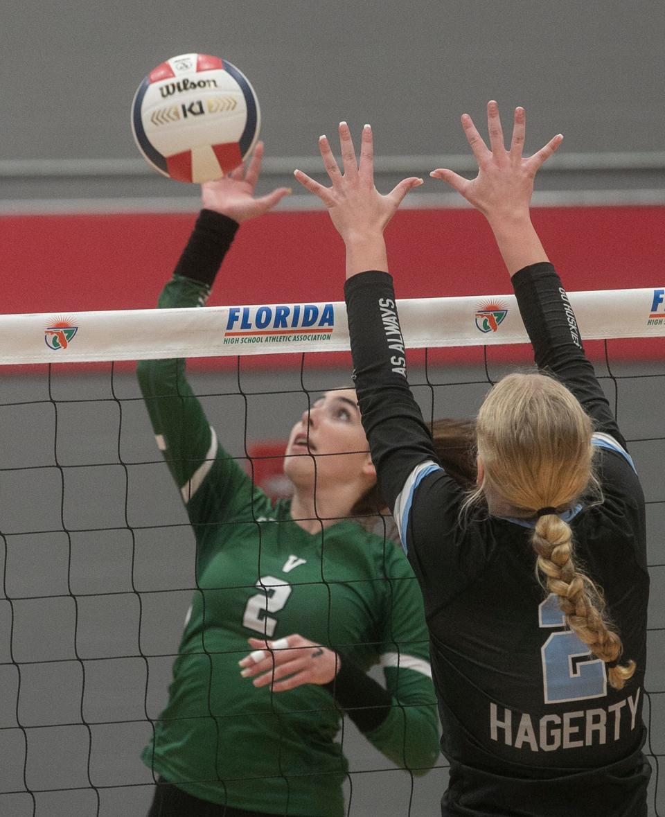 Venice High School's Summer Kohler (2) spikes the ball over the net as Hagerty High School's Brielle Mullen (2) tries to block during their FHSAA Class 7A State Championship volleyball match at Polk State College in Winter Haven Saturday night. November 12, 2022