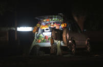 A car displays fruits and vegetables while selling them by the side of a busy road in Harare, Zimbabwe, Tuesday, June 23, 2020. Cars have become mobile markets in Zimbabwe where enterprising residents are selling goods from their vehicles to cope with economic hardships caused by the coronavirus. With their car doors and trunks wide open by the side of busy roads, eager sellers display a colorful array of goods in Harare, the capital. (AP Photo/Tsvangirayi Mukwazhi)