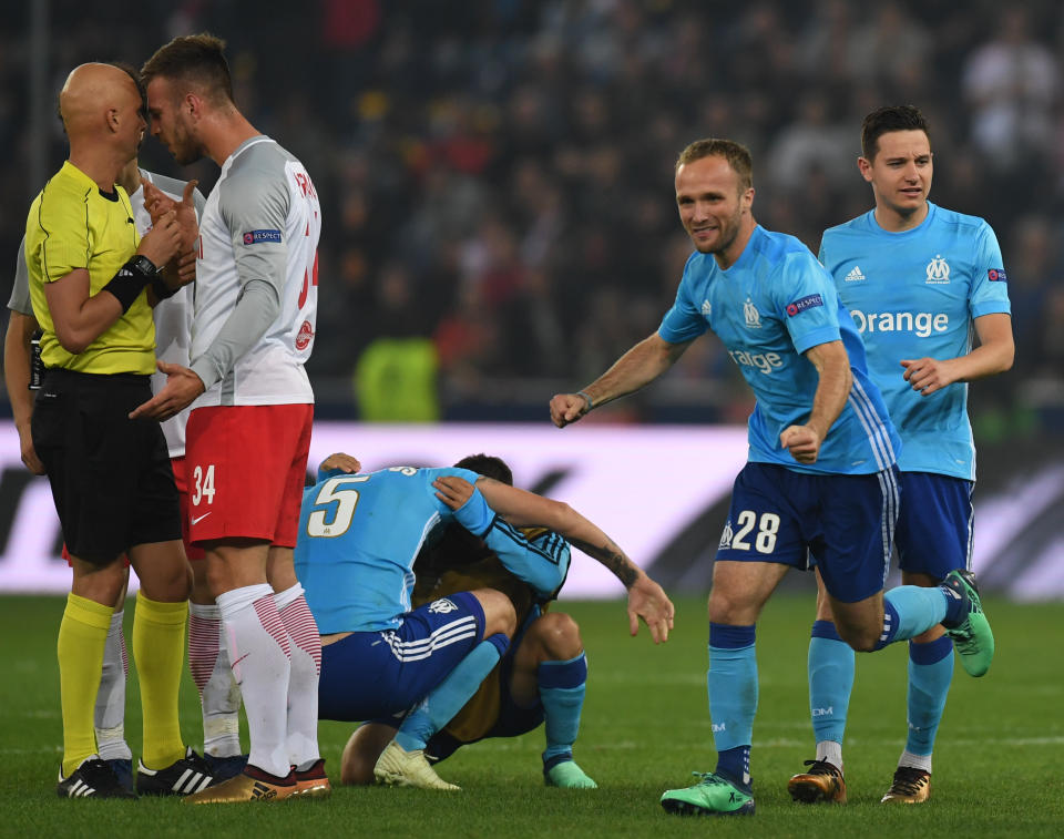A Red Bull Salzburg player confronts the referee as Marseille players celebrate their semifinal victory. (Getty)