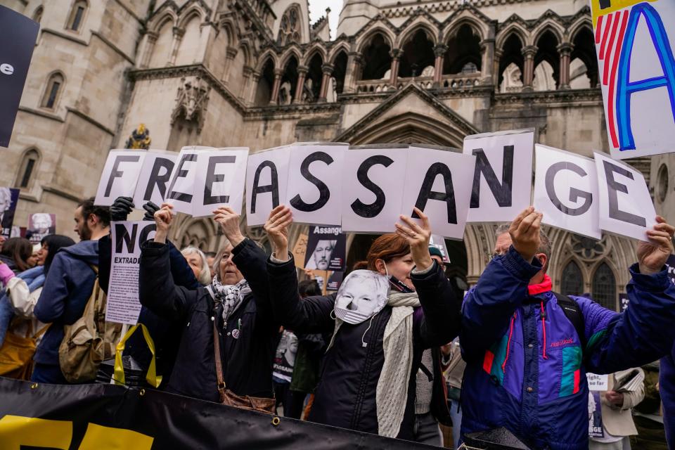 Demonstrators hold banners outside the Royal Courts of Justice in London, Tuesday, Feb. 20, 2024. WikiLeaks founder Julian Assange will make his final appeal against his impending extradition to the United States at the court.