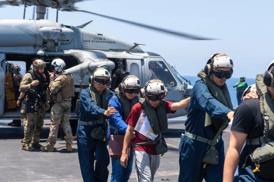 Sailors from the Dwight D. Eisenhower Carrier Strike Group render assistance to distressed mariners at sea in the Red Sea, June 15. <em>U.S. Navy</em>