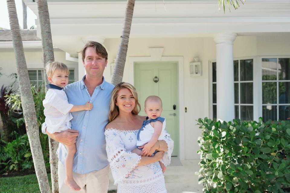 Alex Canet holds son Nicolas and Charlotte Ross Canet holds daughter Sophie in front of the house they are selling at 240 El Dorado Lane on the North End in Palm Beach.