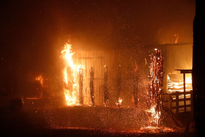 A burning structure is seen during the wind-driven Kincade Fire in Windsor