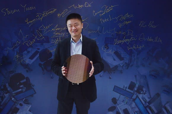 An executive from Arm holding a test wafer of Intel 10-nanometer chips.