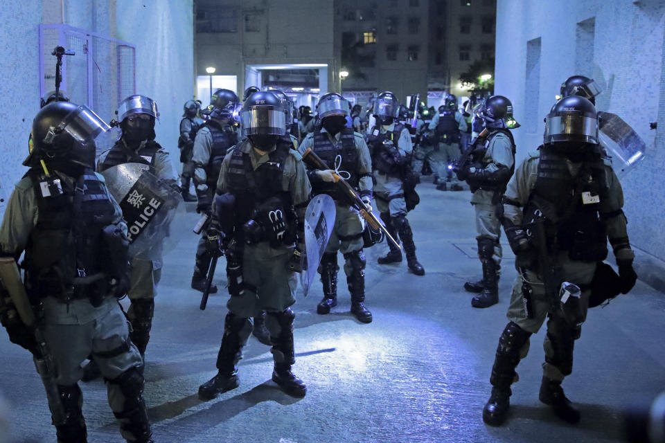 Police officers at a housing estate after clashing with protesters in Hong Kong, early Saturday, Nov. 9, 2019. A Hong Kong university student who fell off a parking garage after police fired tear gas during clashes with anti-government protesters died Friday in a rare fatality in five months of unrest, fueling more outrage against authorities in the semi-autonomous Chinese territory. (AP Photo/Kin Cheung)