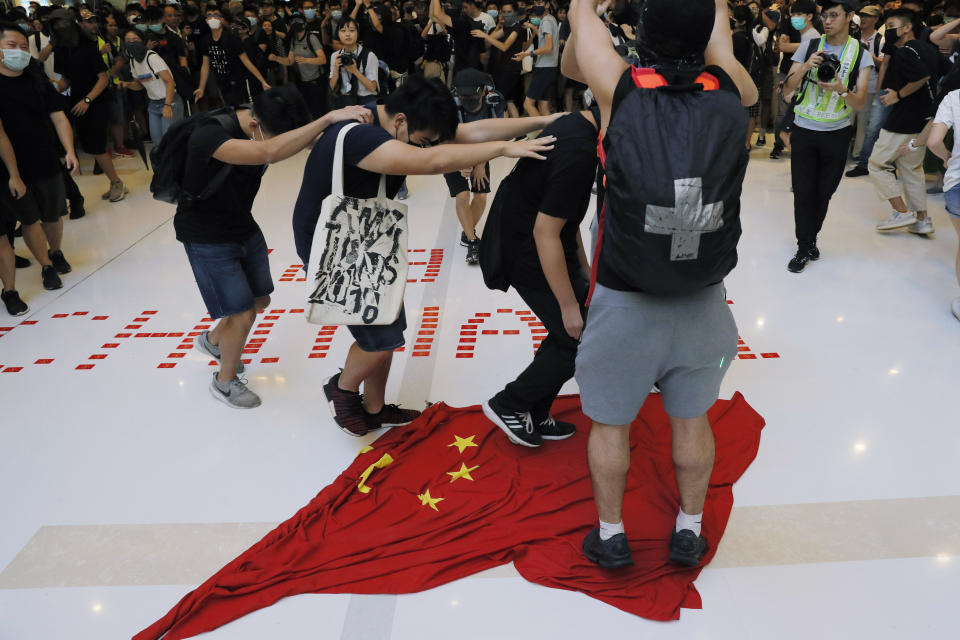 In this Sunday, Sept. 22, 2019, photo, protesters walk on a Chinese national flag during a protest at a mall in Hong Kong. China's decision to impose a national security law on Hong Kong is raising questions about the future of the semi-autonomous Chinese territory. The move bypasses Hong Kong's government _ which has not been able to enact such a law despite a requirement that it does _ and could allow the stationing of Chinese security officers in the city. A look at what it means and why people are concerned. (AP Photo/Kin Cheung)