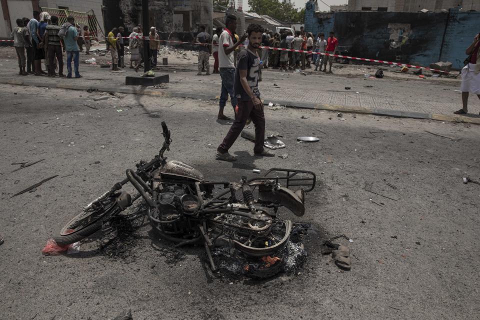 Civilians gather at the site of a deadly attack in Aden, Yemen, Thursday, Aug. 1, 2019. Yemen's rebels fired a ballistic missile at a military parade Thursday in the southern port city of Aden as coordinated suicide bombings targeted a police station in another part of the city. The attacks killed over 50 people and wounded dozens. (AP Photo/Nariman El-Mofty)