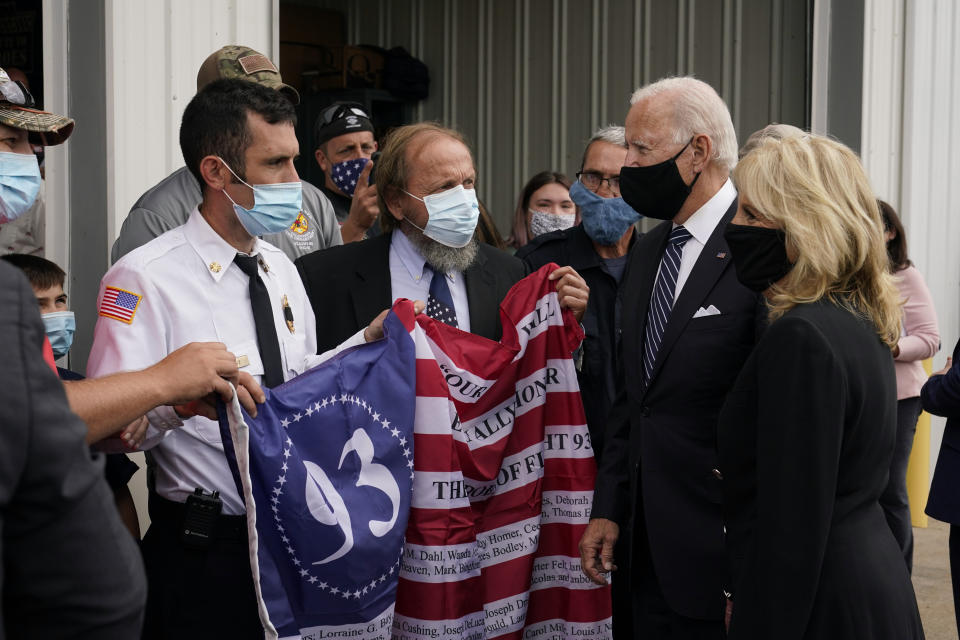 Members of the Shanksville Volunteer Fire Department present a flag to Democratic presidential candidate and former Vice President Joe Biden and his wife Jill Biden during a visit in Shanksville, Pa., Friday, Sept. 11, 2020. The Bidens stopped by after visiting the nearby Flight 93 National Memorial to commemorate the 19th anniversary of the Sept. 11 terrorist attacks. (AP Photo/Patrick Semansky)
