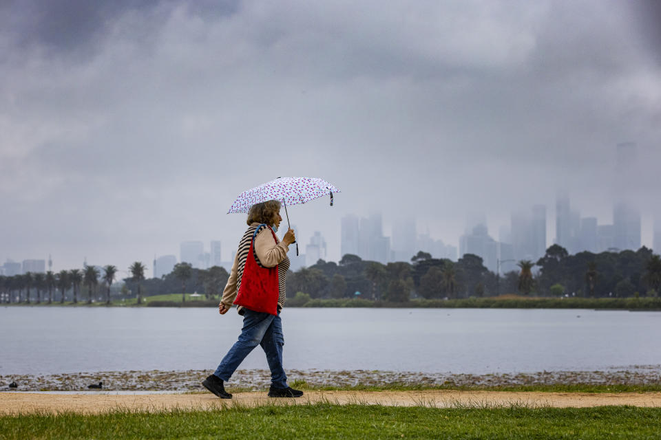 A person is seen walking in the rain at Albert Park Lake in Melbourne, Thursday, September 30, 2021