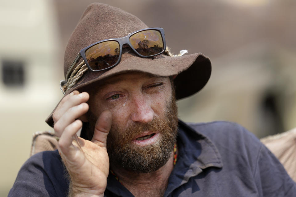 Mr Graham wipes a tear as he talks about his dog, Kozi, while camping on the lawn near the fire station at Nerrigundah. Source: AAP