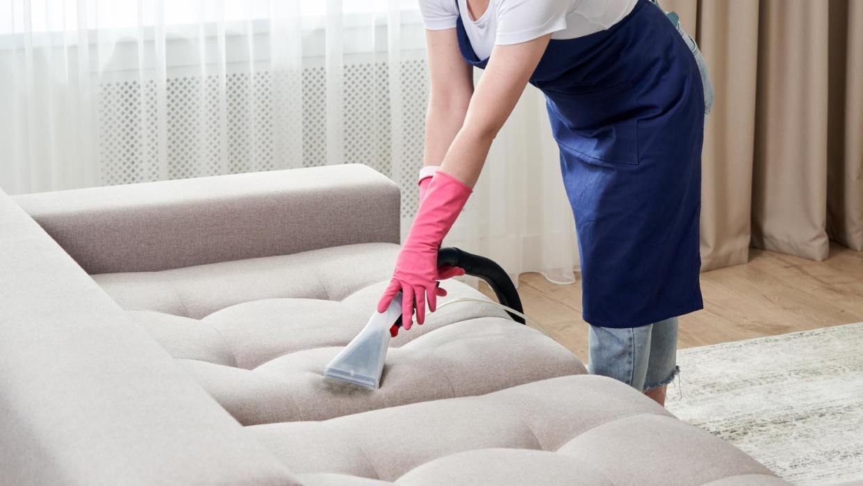 A woman cleaning a sofa