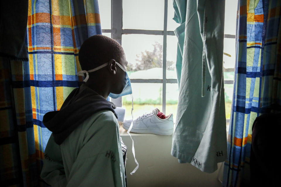 FILE - In this May 1, 2020, file photo, a patient looks out of the window in a ward for those who have tested positive for the new coronavirus, at the infectious disease unit of Kenyatta National Hospital, located at Mbagathi Hospital, in Nairobi, Kenya. A dangerous stigma has sprung up around the coronavirus in Africa — fueled, in part, by severe quarantine rules in some countries as well as insufficient information about the virus. (AP Photo/Brian Inganga, File)