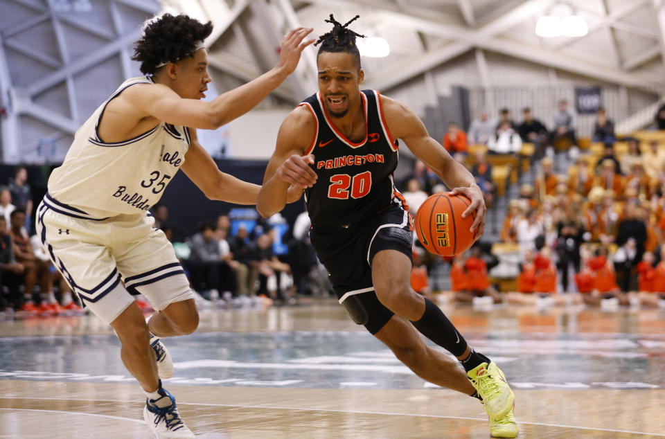 Princeton forward Tosan Evbuomwan (20) drives to the basket against Yale forward Isaiah Kelly (35) during the first half of the Ivy League championship NCAA college basketball game, Sunday, March 12, 2023, in Princeton, N.J. (AP Photo/Noah K. Murray)