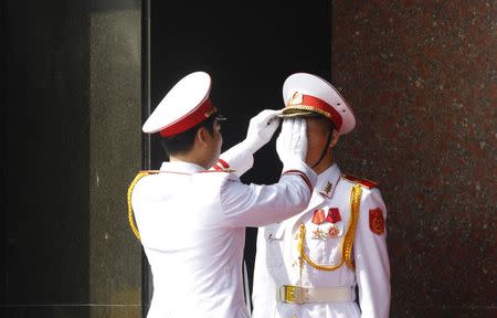 An military officer adjusts the attire of an honour guard before a wreath-laying ceremony attended by China's President Xi Jinping at the mausoleum of late Vietnamese revolutionary leader Ho Chi Minh in Hanoi, Vietnam, November 6, 2015. REUTERS/Kham
