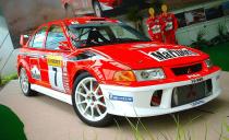 By the time of the Evo VI’s introduction in 1999, the car’s performance reputation was well known globally and sales began in markets like Germany—where it was known as the Carisma GT—and Great Britain. The Evo was a legend in its own time.<br><br> Besides the usual RS and GSR versions of the Evo VI, new RS2 and RS Sprint models were introduced. And in 1999, a Tommi Mäkinen Edition was introduced flying similar paint designs (in several colors) as the great driver’s rally rides. Other changes in the Tommi Mäkinen Edition included trim variations, Recaro seats with special logos, and aerodynamic tweaks. This model is sometimes referred to as the “Evo 6.5” and is considered collectible. At this point, however, Mitsubishi still wasn’t exporting the Evo to the United States.