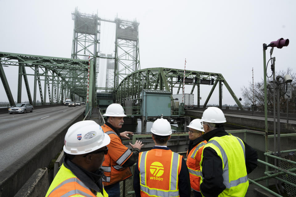 U.S. Transportation Secretary Pete Buttigieg, center, tours the century-old Interstate 5 bridge that spans the Columbia River and connects Portland, Ore., with southwest Washington state on Tuesday, Feb. 13, 2024, with Oregon Gov. Tina Kotek, second from right, and Washington Gov. Jay Inslee, near the Washington state entrance to the bridge. The bridge is set to be replaced as part of a multibillion-dollar project supported by federal funding. (AP Photo/Jenny Kane)
