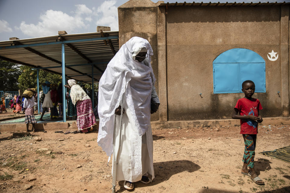 Zenabou Coulibaly Zongo, consultant and founding member of the Council of Burkinabe Women, leaves the mosque in Ouagadougou, Burkina Faso, Friday, Oct. 29, 2021. Zongo spends her own money making soap and buying hand sanitizer for mosques, markets and health centers. At the start of the pandemic, Zongo, now 63, was hospitalized with bronchial pneumonia. She paid out of pocket for two weeks' worth of oxygen treatments at a private clinic, where she watched others die from respiratory problems. (AP Photo/Sophie Garcia)