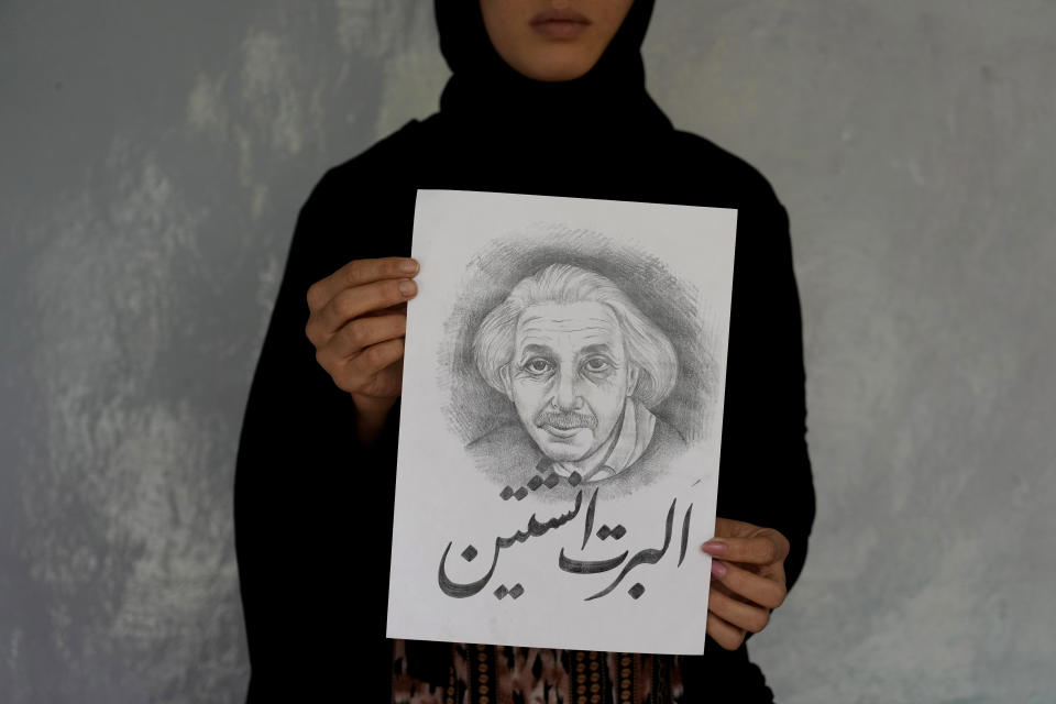 Zahra, a sister of 20-year-old Vahida Heydari, who was victim of a suicide bombing on a Hazara education center, shows a painting titled "Albert Einstein" that was drawn by Heydari, in Kabul, Afghanistan, Sunday, Oct. 2, 2022. She liked physics and admired Einstein. Last week’s suicide bombing at the Kabul education center killed as many as 52 people, more than double the death toll acknowledged by Taliban officials, according to a tally compiled by The Associated Press on Monday. (AP Photo/Ebrahim Noroozi)