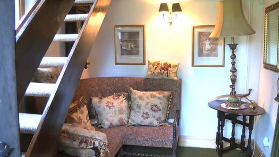 Winwick polling station - a sofa with cushions and small table are seen beneath the stairs