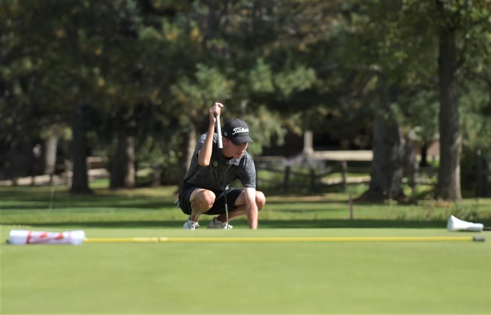 Fossil Ridge golfer Austin Barry kneels down to line up his putt during the Colorado 5A boys golf state championships on Tuesday, Oct. 3, 2023 at Collindale Golf Course in Fort Collins, Colo.