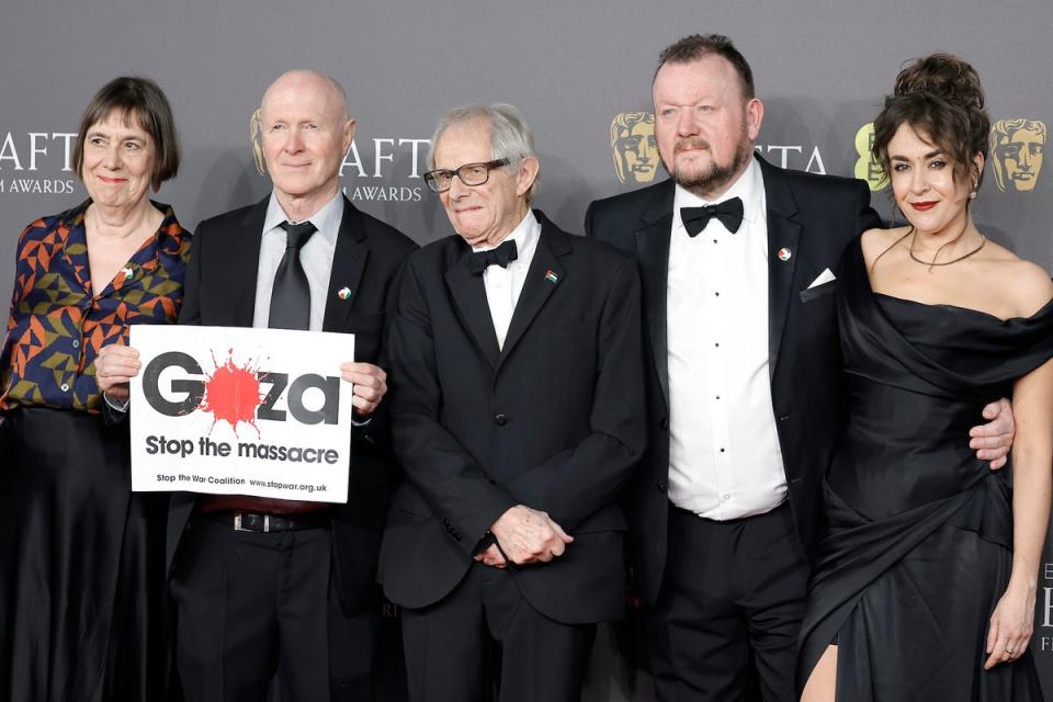 Ken Loach, centre, stands next to a sign reading ‘Gaza: Stop the Massacre’ on the red carpet (Getty Images)