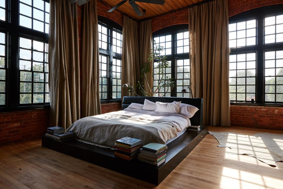 In the light-filled master bedroom, Ingram draped the windows with curtains made from fabric from Rose Brand. The custom platform bed and headboard are her own design.