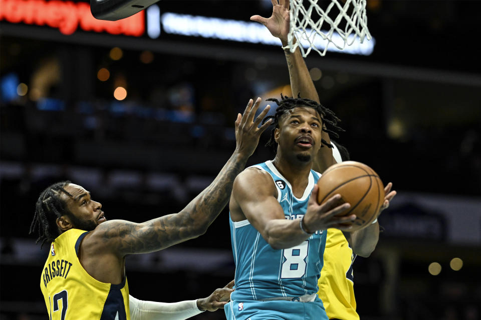 Charlotte Hornets guard Dennis Smith Jr. (8) drives past Indiana Pacers forward Oshae Brissett, left, for a layup during the first half of an NBA basketball game, Monday, March 20, 2023, in Charlotte, N.C. (AP Photo/Matt Kelley)