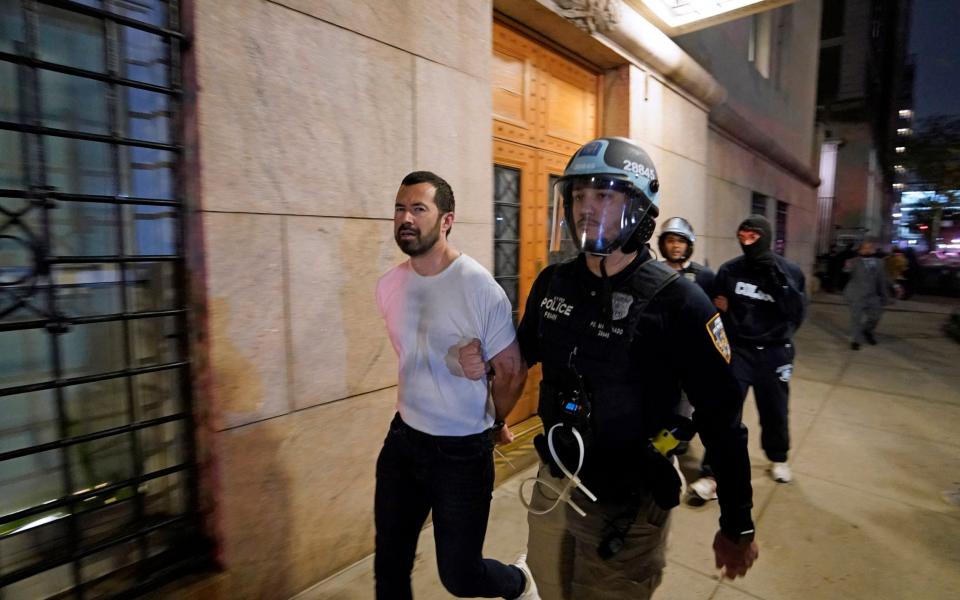 A NYPD officer arrests a student