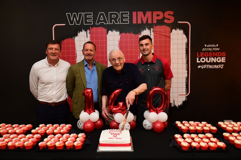 Lincoln City supporter Trevor Stacey cuts a cake to mark the club’s 140th birthday. Trevor is the son of Bill Stacey, one of two Lincoln City fans who died in the Valley Parade fire. He is joined by (L-R) Lincoln City’s record appearance holder Grant Brown, club director David Lowes and first-team captain Paudie O’Connor